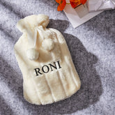 בקבוק חימום בצבע שמנת עם שם וכיסוי קטיפה רך ונעים